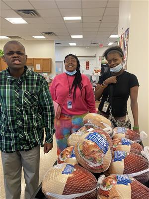 Students standing next to frozen turkeys